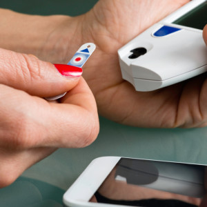 Placing test stip in blood sugar meter with smart phone help